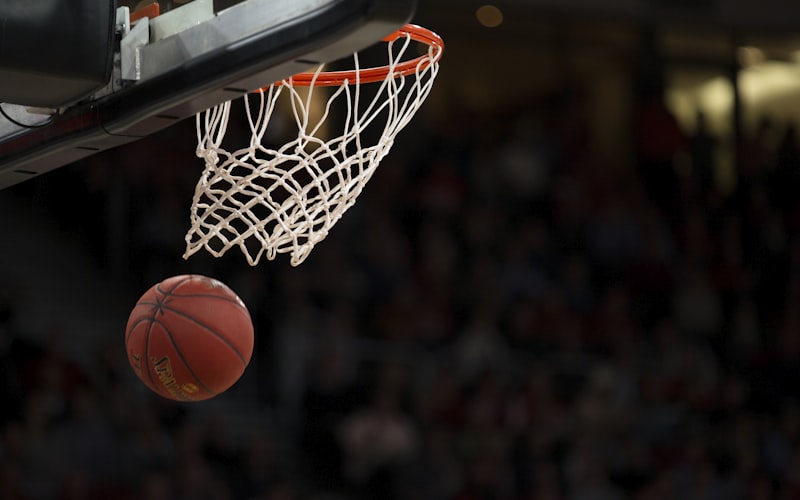 NBA比赛中球员完成隔人暴扣的震撼画面，展现惊人弹跳力